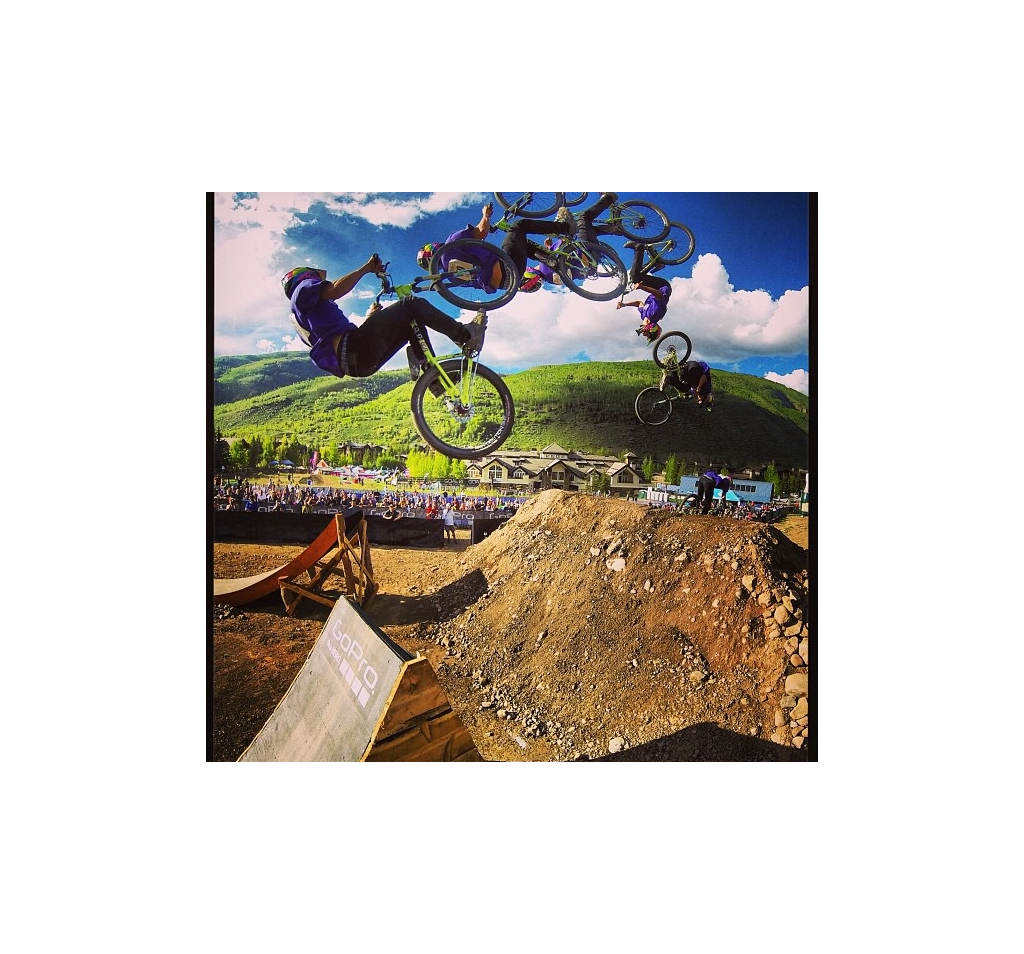 Continuous photo of biker catching major air and doing a flip off a jump.