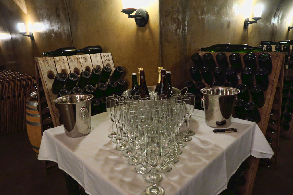 Wine bottles in holders, and empty glasses on table ready to be used.