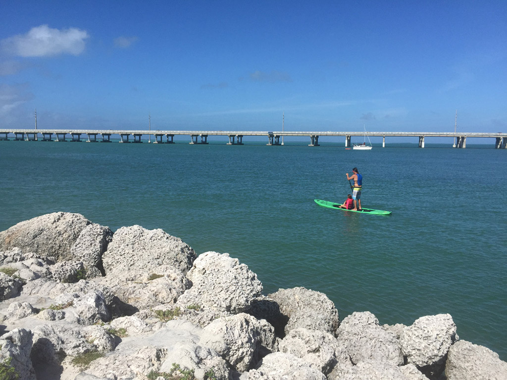 Craig paddleboarding with one of the kids on the ocean.