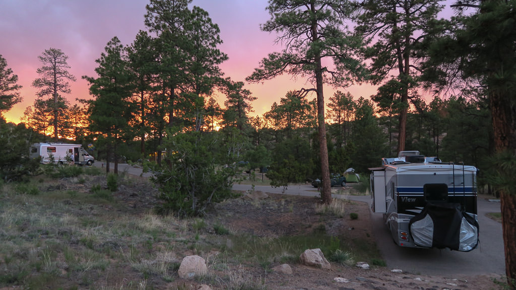 Winnebago View in campsite with colorful sunset lighting up the sky.