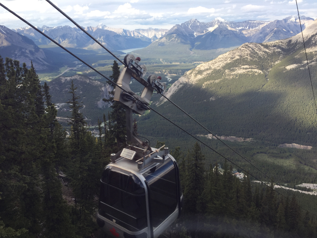 Banff Gondola overlooking breath-taking mountain range with trees and rivers running below.