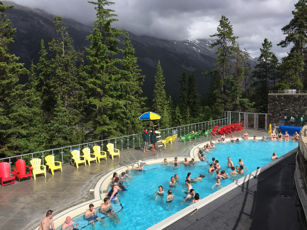 Pool  that is Banff Hot Springs on a deck overlooking the mountains.