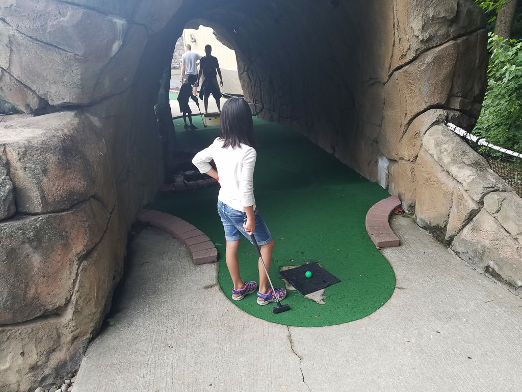 A family playing mini golf