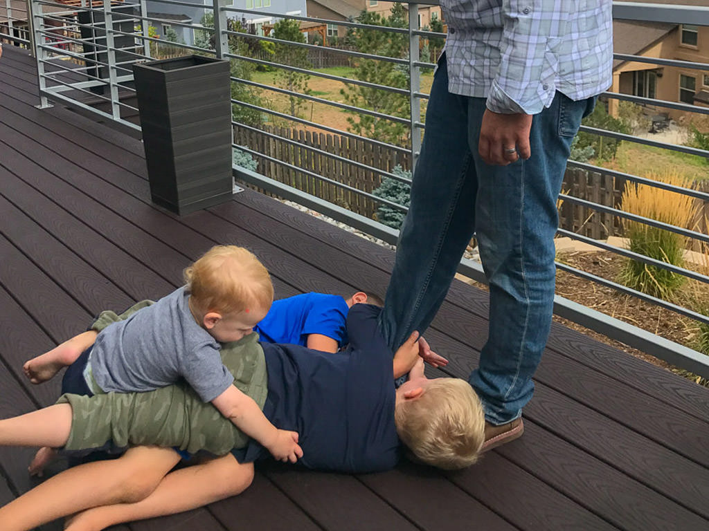 Kids playing together on a deck.