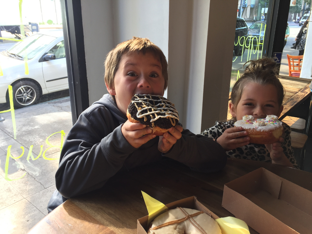 Two of the kids eating huge donuts