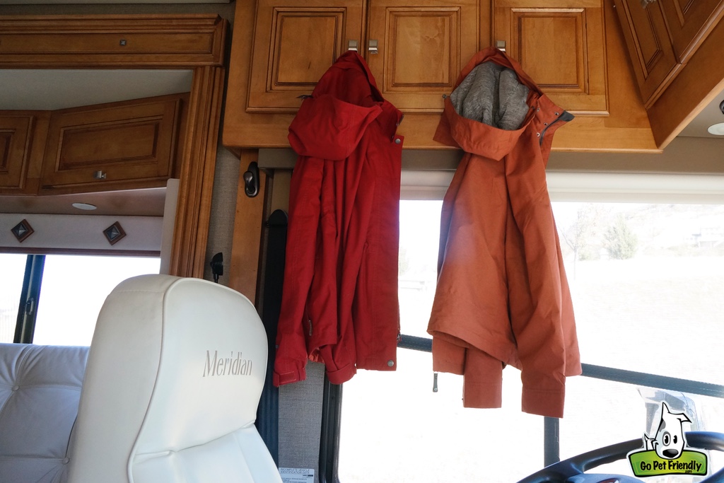 Two rain jackets hanging on cabinets in RV