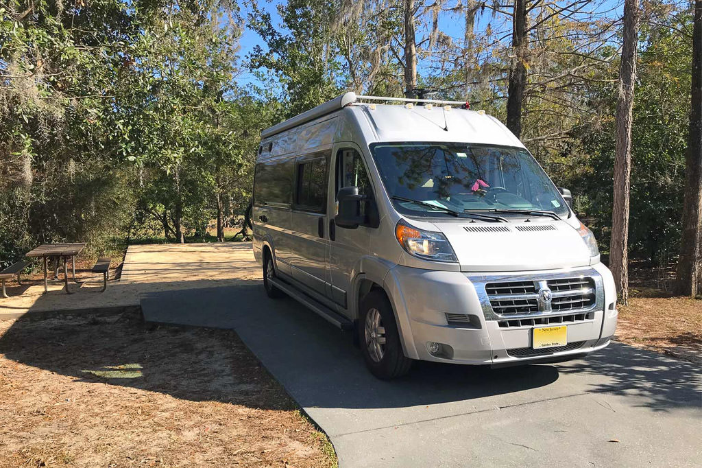 RV on paved site with picnic bench in campground